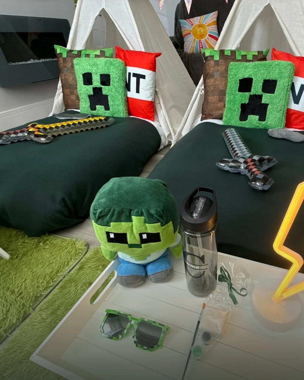 Teepees styled for a Minecraft sleepover with creeper cushions, green bedding and pixel swords