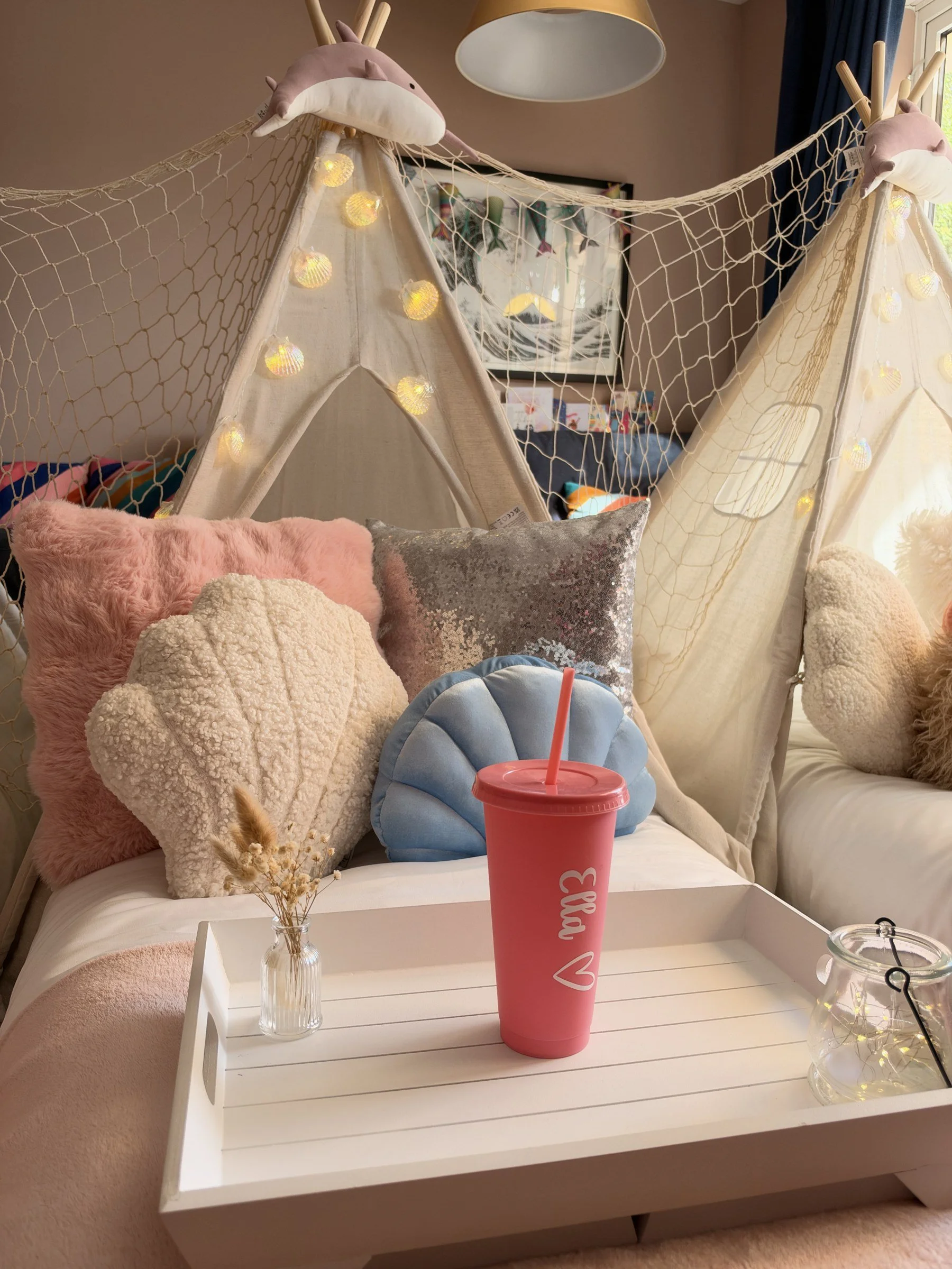 Personalised cup and shell cushions on a styled tray at a mermaid teepee sleepover party in Hampshire