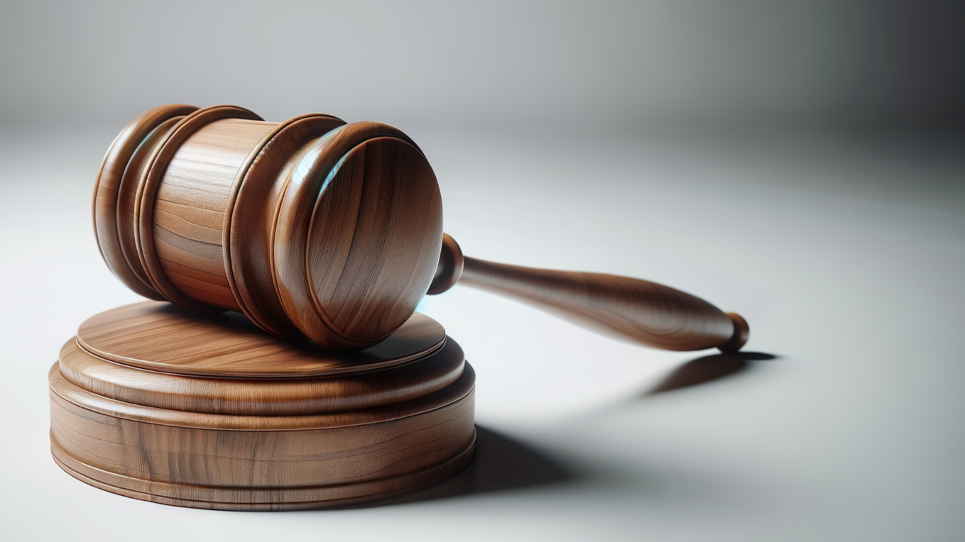 Wooden gavel resting on a sound block.
