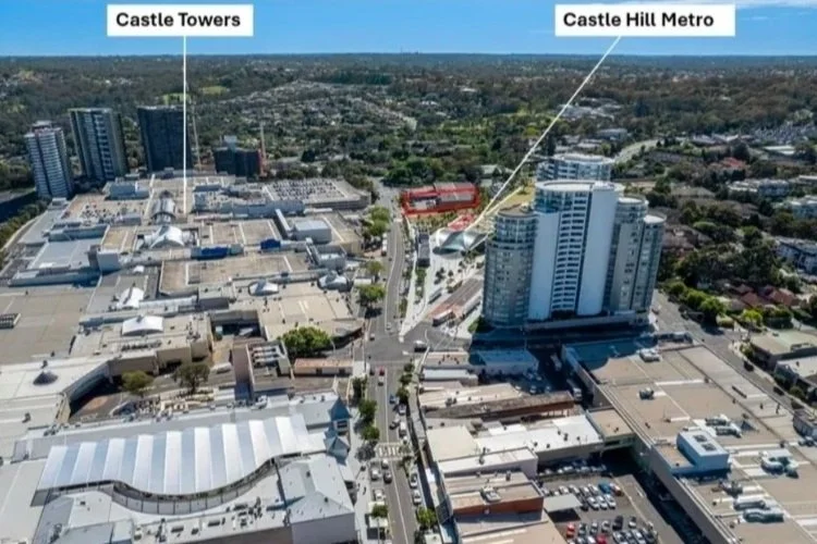 Aerial view of a cityscape with labeled landmarks, including Castle Towers, a shopping mall, and Castle Hill Metro, a high-rise building.
