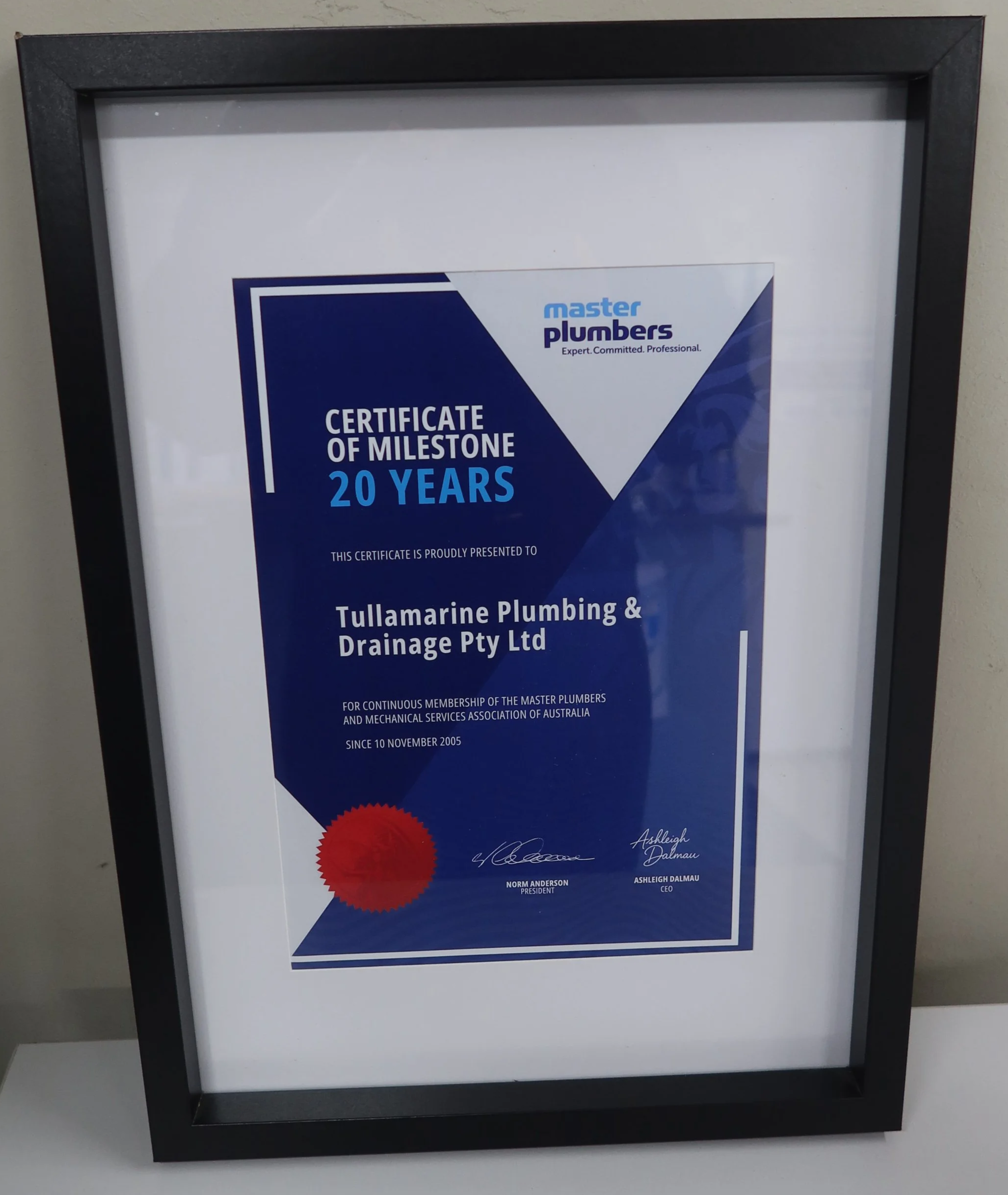 Framed certificate of milestone for 20 years awarded to Tullamarine Plumbing & Drainage Pty Ltd, issued by Master Plumbers, with signatures of officials and a red seal.