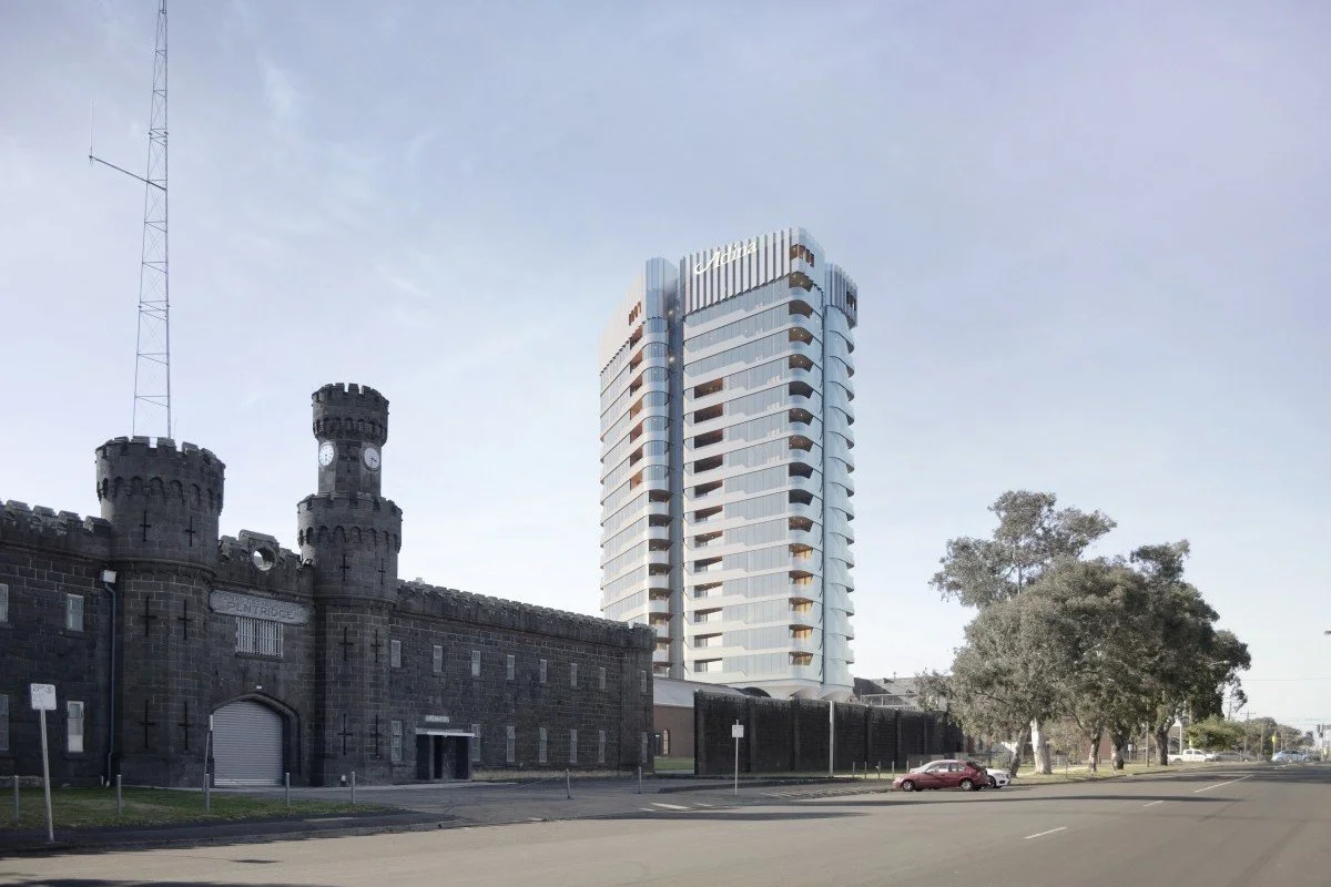 Exterior view of a large scale commercially constructed apartment complex with the iconic pentridge prison front entrance beside it