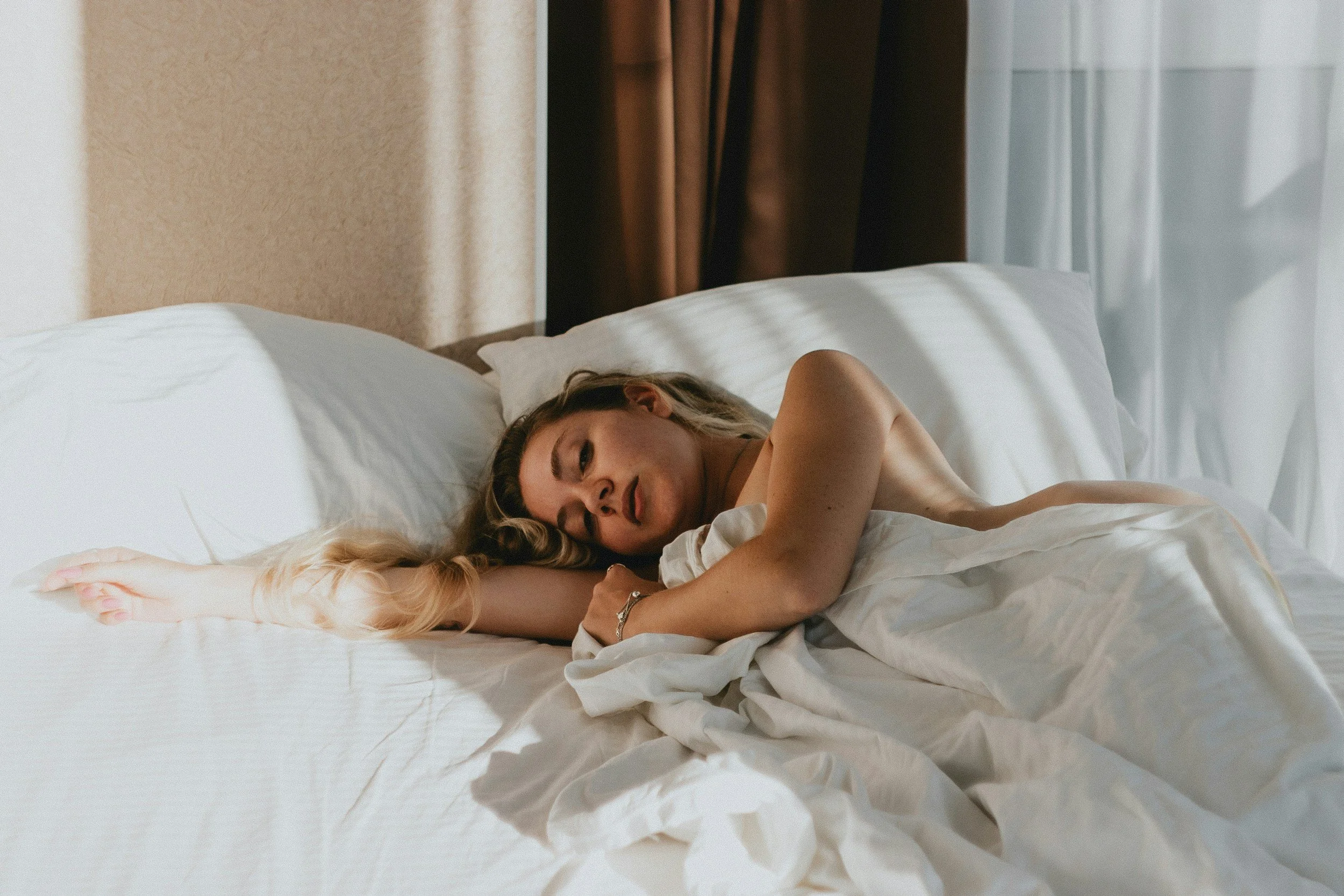 Woman sleeping under a lightweight, breathable cotton muslin blanket
