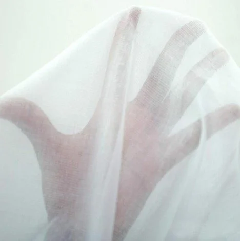 Close-up of lightweight cotton muslin showing its soft, breathable open weave