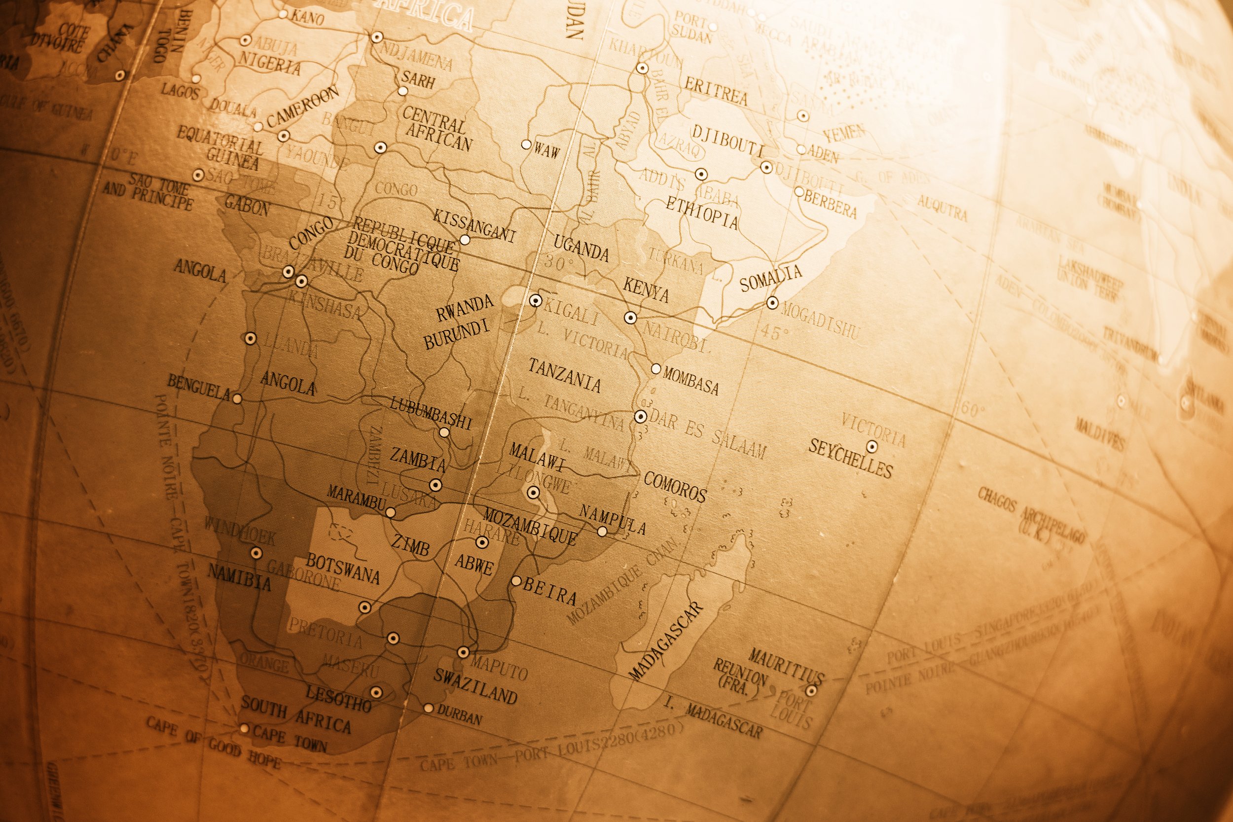 A vintage world globe showing Africa and surrounding regions with country names, borders, and major cities marked.