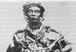 Black and white photo of a man wearing a military uniform with medals, holding a rifle.