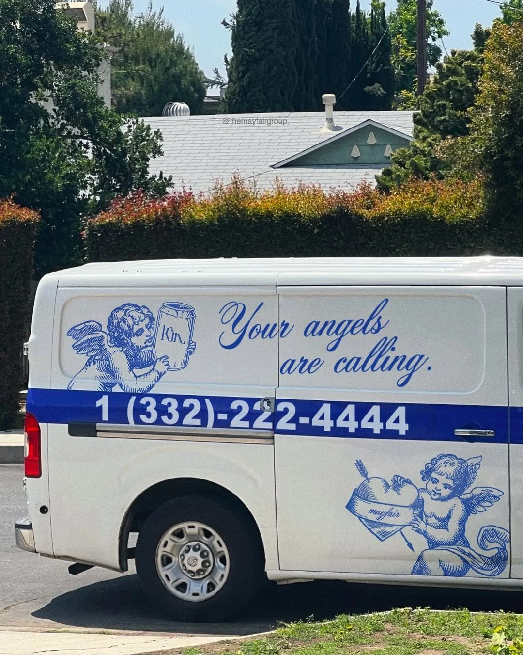 A white van with blue graphics and text. The text reads, "Your angels are calling," and includes a phone number. The graphics depict two cherubic angels; one holding a beer mug labeled 'Kin' and the other holding an arrow and a bowl of fruit labeled 'mayfair.'"}}#}about:blank#}'}]},{},{