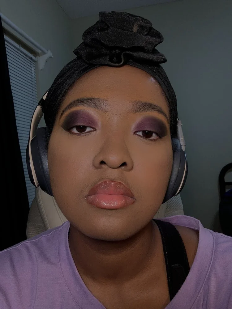 Alona in purple eyeshadow and headphones