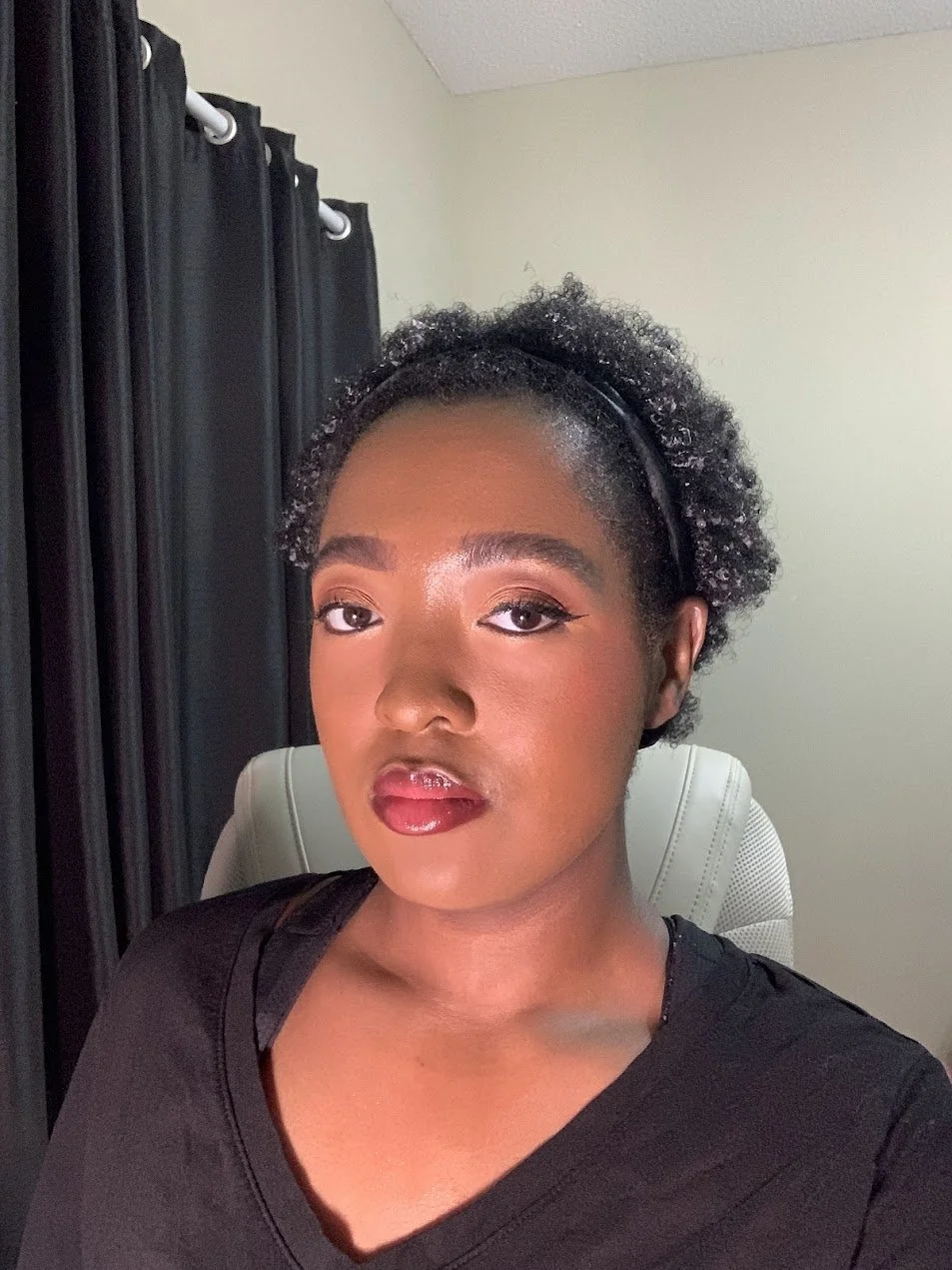 Alona Shardae in red lipstick, sitting in a white chair