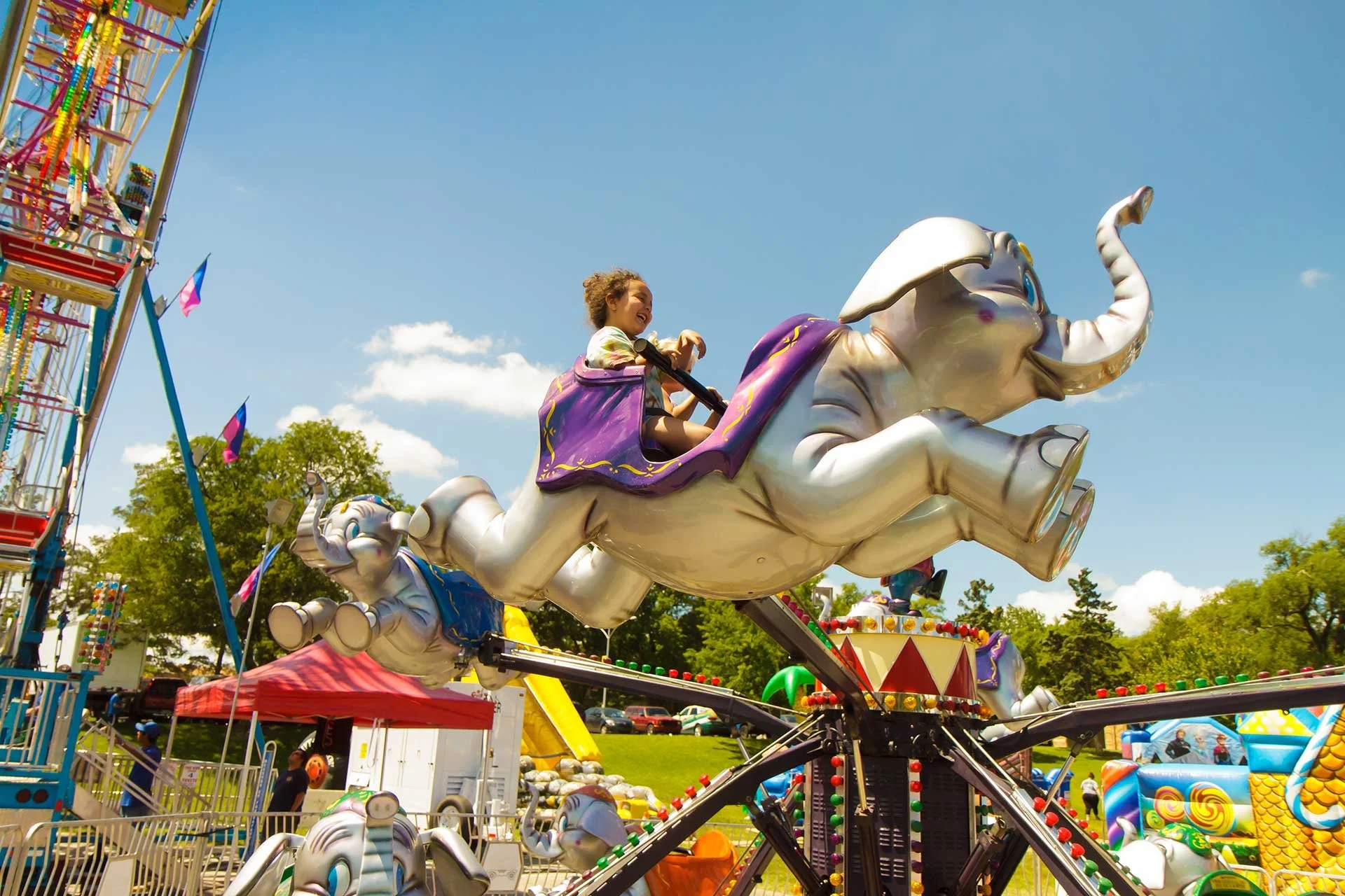 Girl riding a flying elephant ride