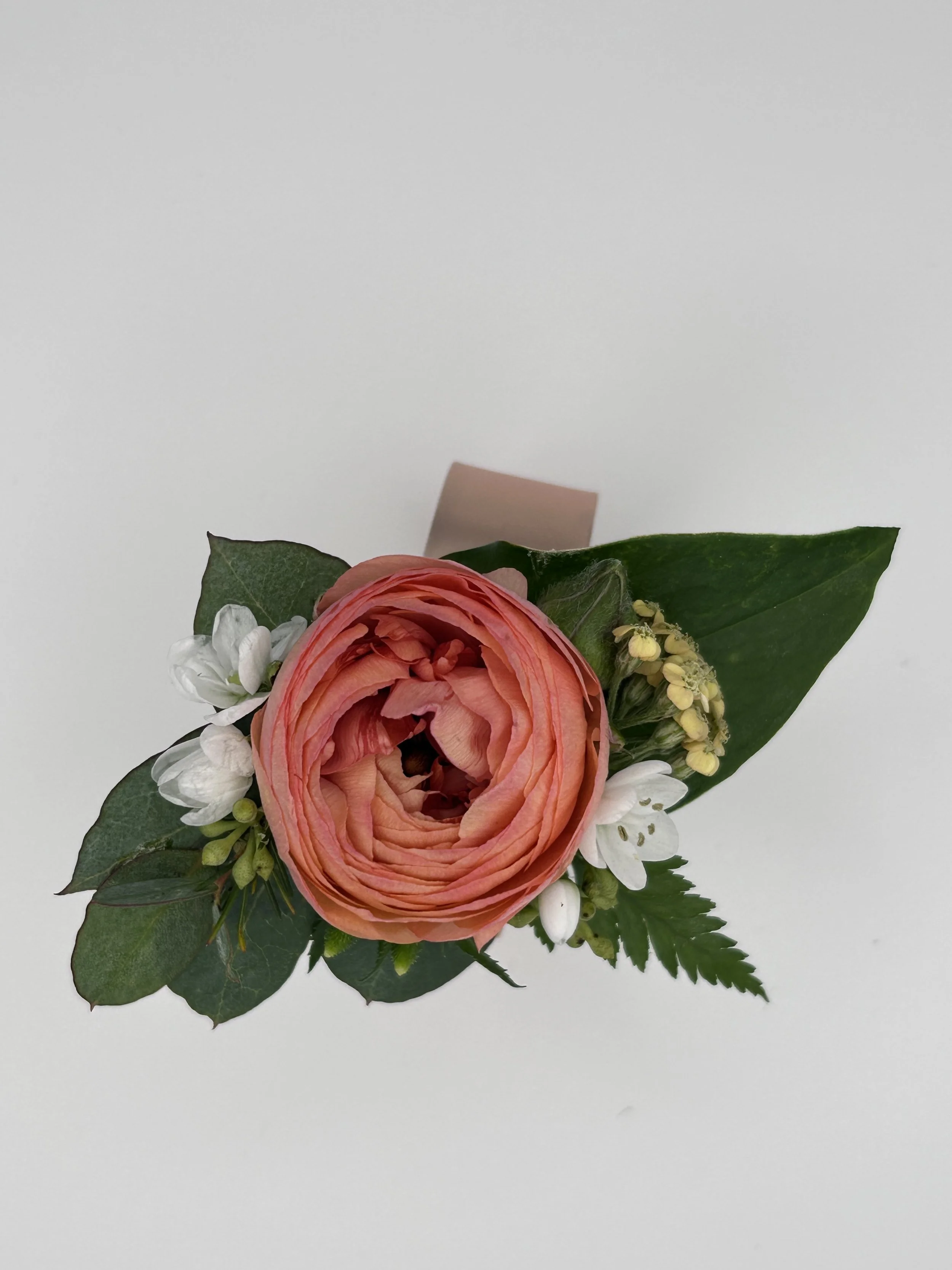 Bespoke wrist cuff by Worn and Wild Florals featuring a red ranunculus, white rose, and eucalyptus — handcrafted fresh floral wearable, Calgary