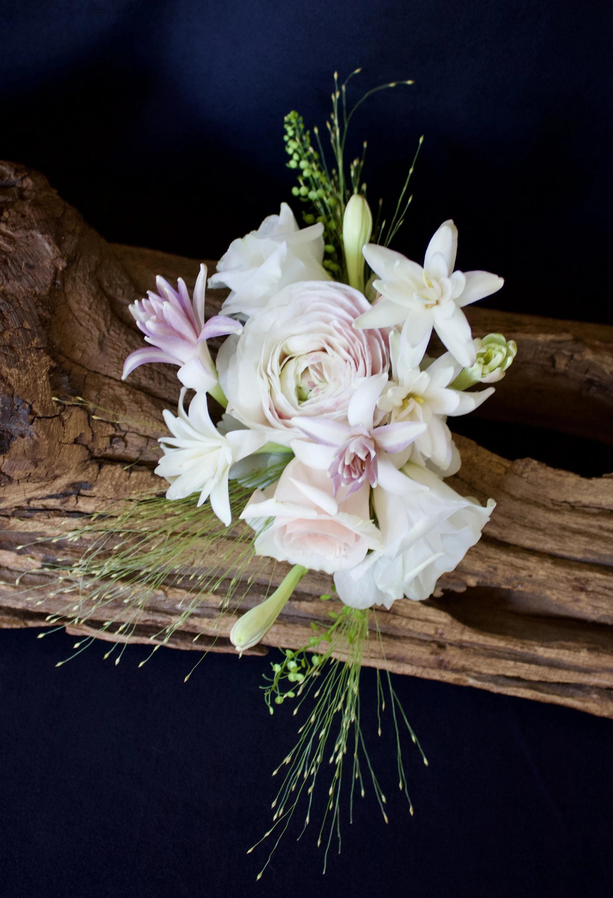 Bespoke floral boutonnière with white and pink blooms on driftwood — wearable floral art by Worn & Wild, Calgary