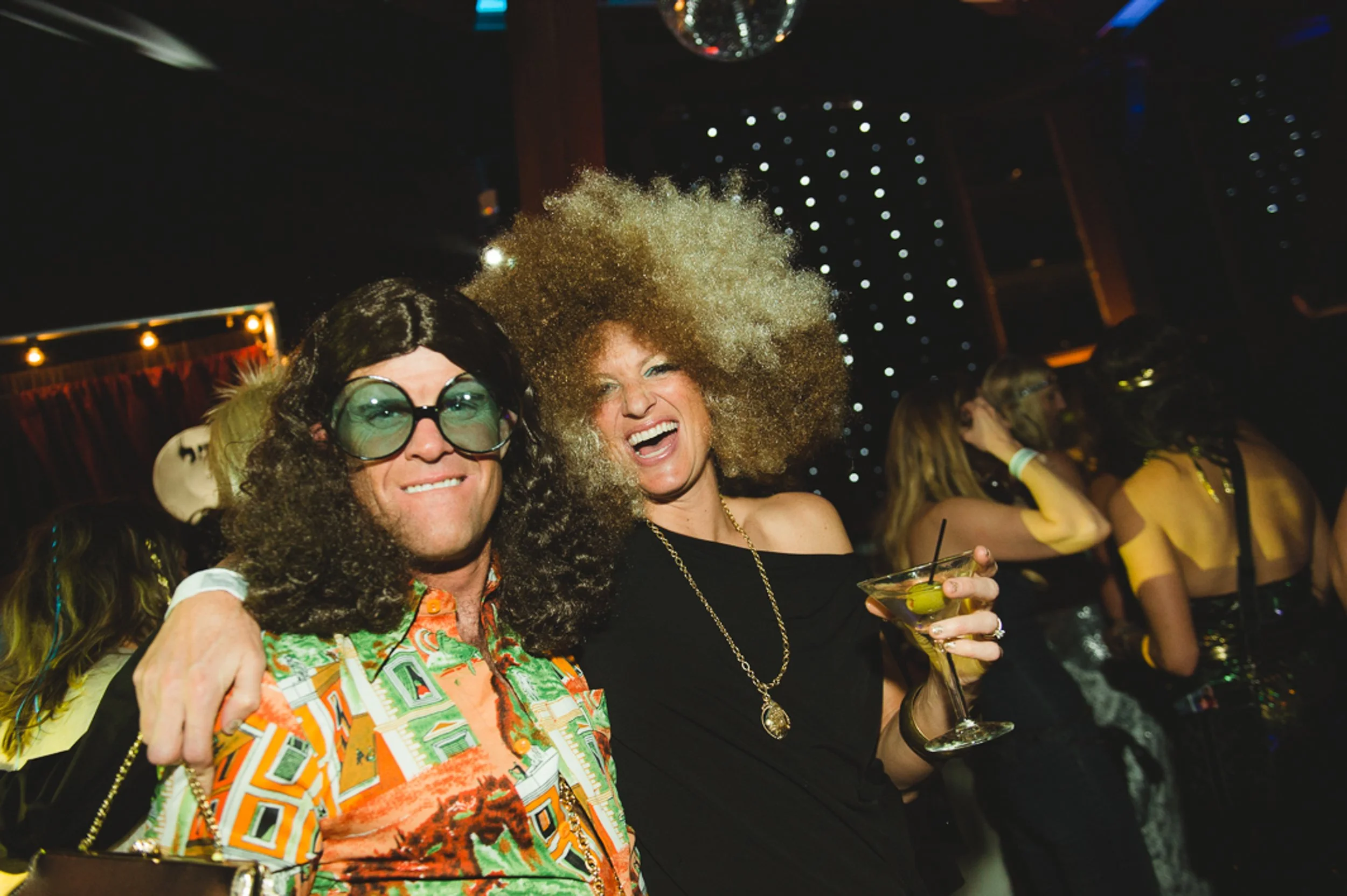 Guests in costume having fun at fundraiser event candid moment captured with retro camcorder rental