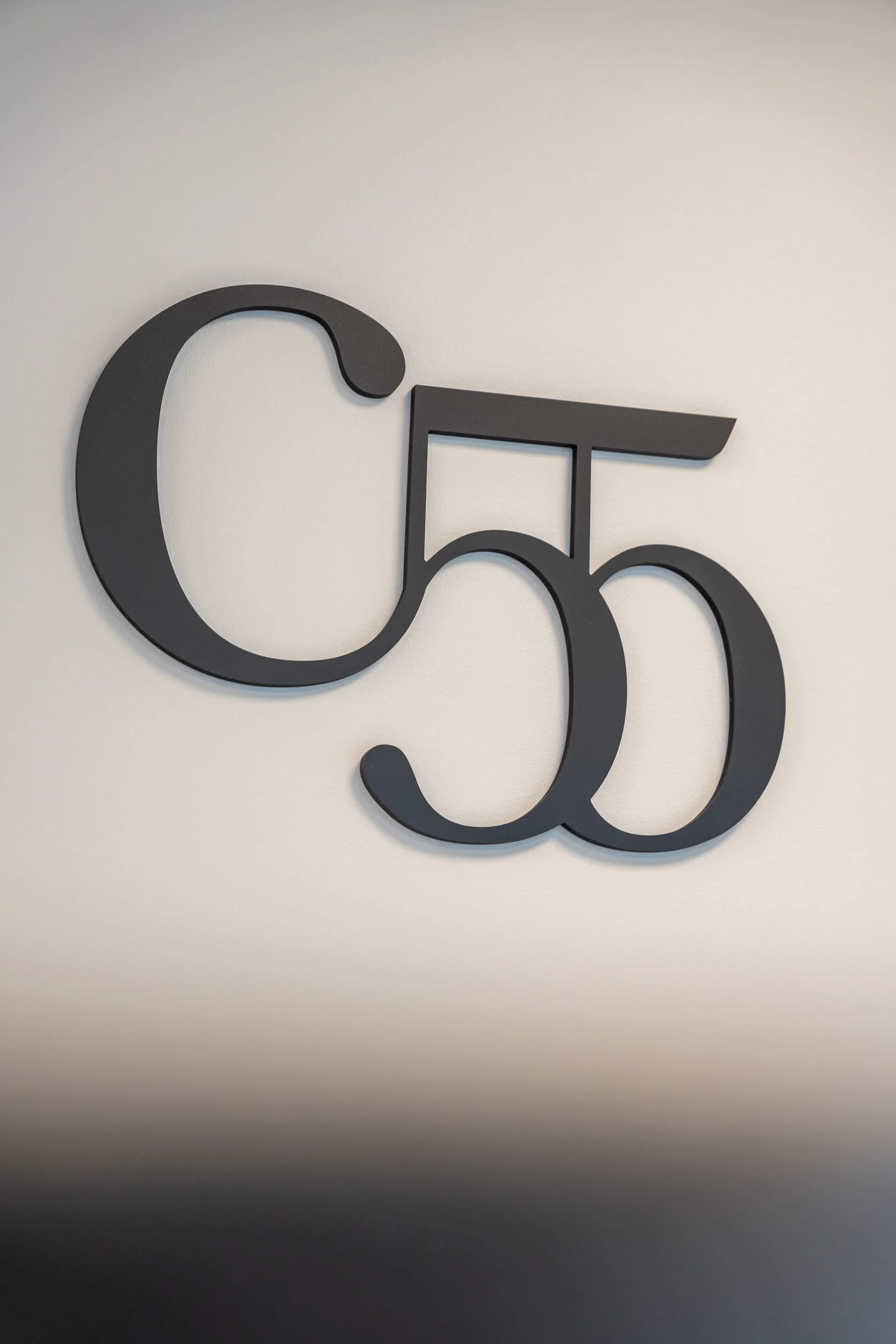 Store svarte bokstaver som danner ordene "C 55" på en lys bakgrunn.