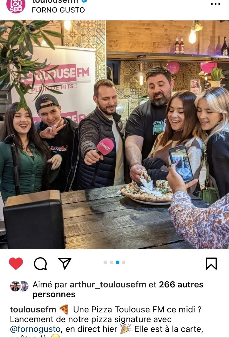 Influenceurs autour d'une table dégustant une pizza dans un restaurant toulousain.