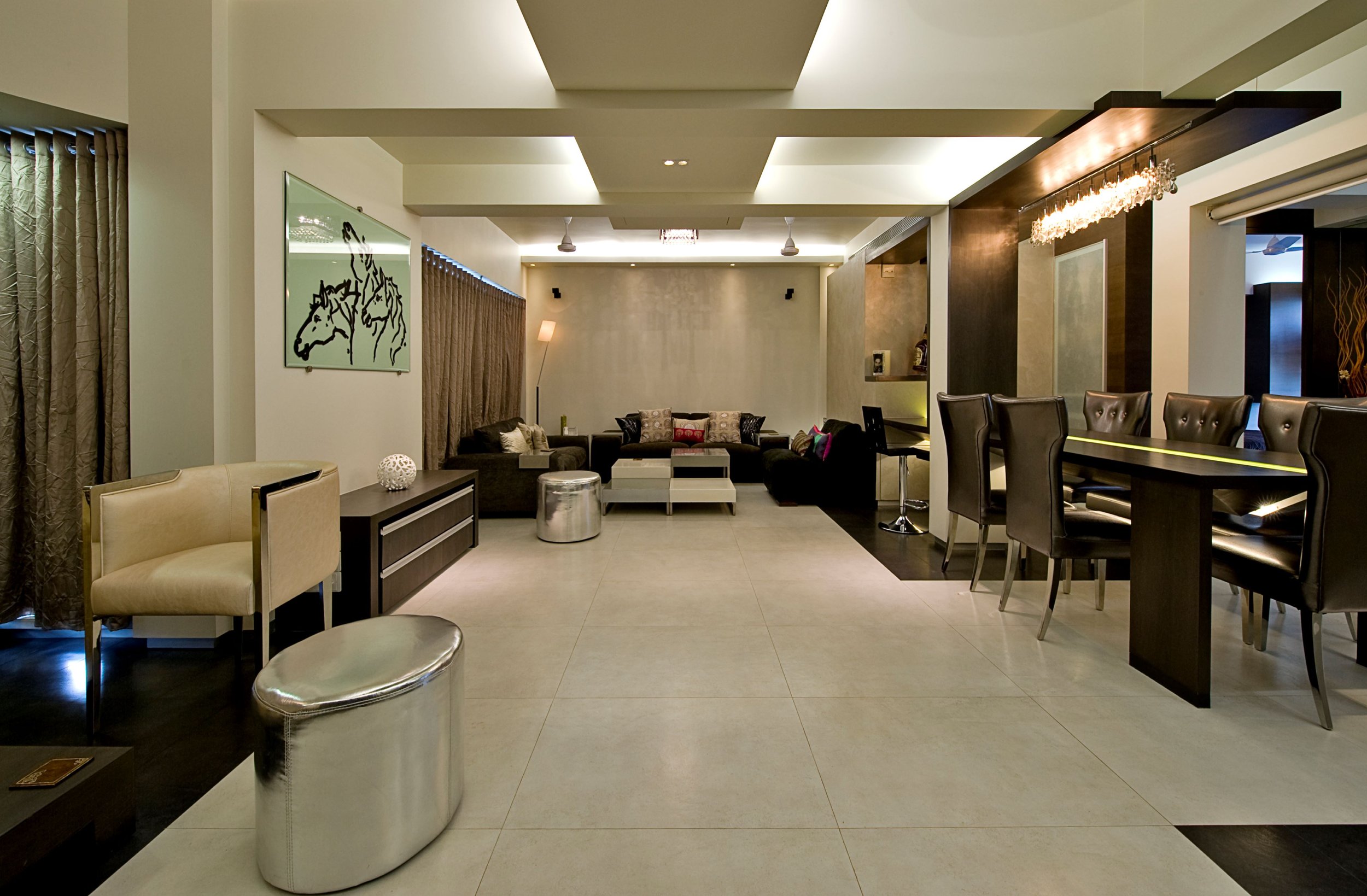 Modern hotel lounge with seating area, wall art, and a bar with high chairs.