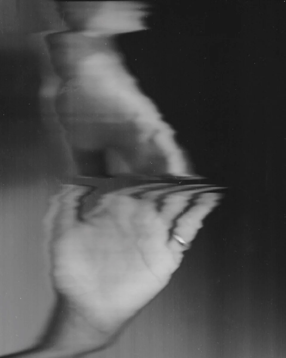 black and white image of hand reaching upwards and wobbling out of focus