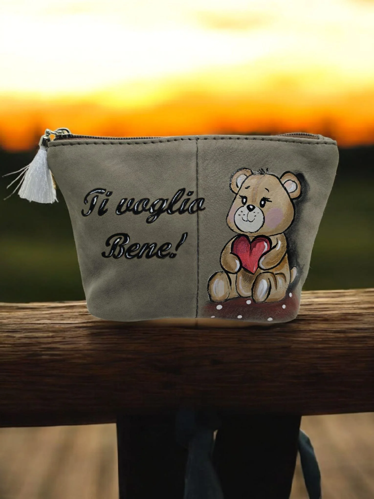 Una bustina di materiale beige con disegnata un'orsetta che tiene un cuore rosso, con la scritta in italiano 'Ti voglio bene!'.