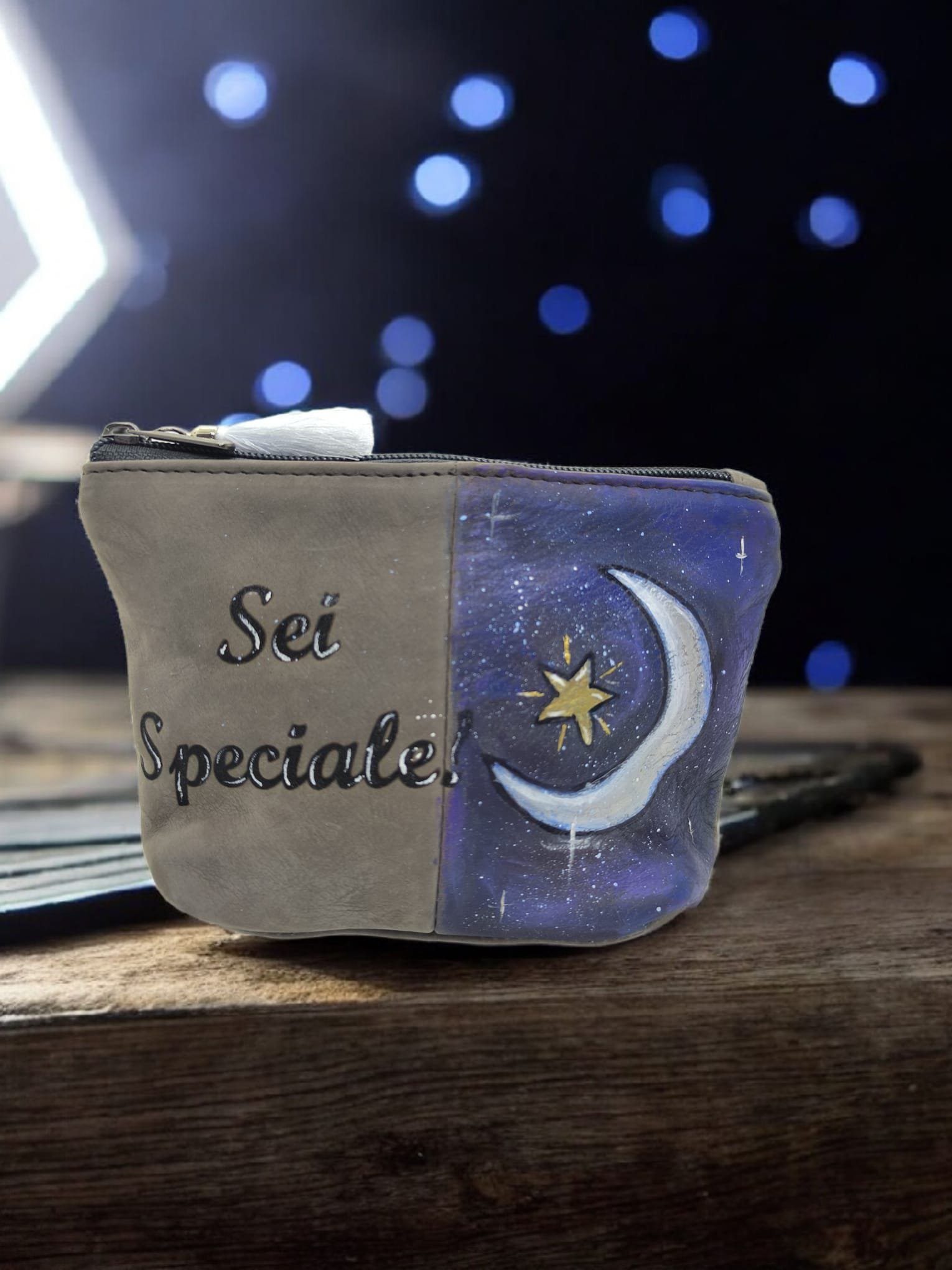 Fazzoletto colorato con una frase in italiano, in una scatola decorata con un disegno di una luna e stelle, sul tavolo di legno.