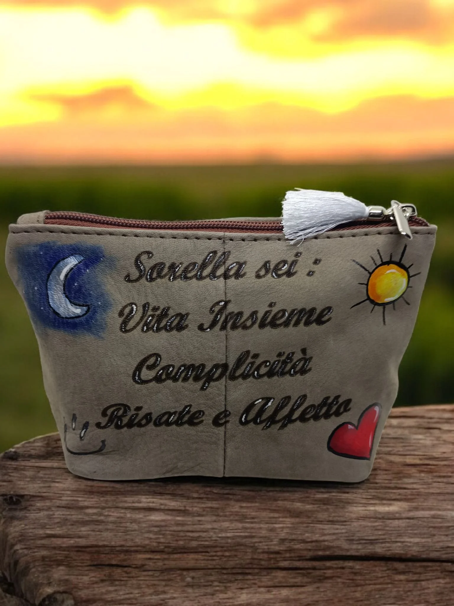 Bomboniera di stoffa con scritte e disegni, tra cui un sole, una luna e un cuore rosso, con scritte in italiano.