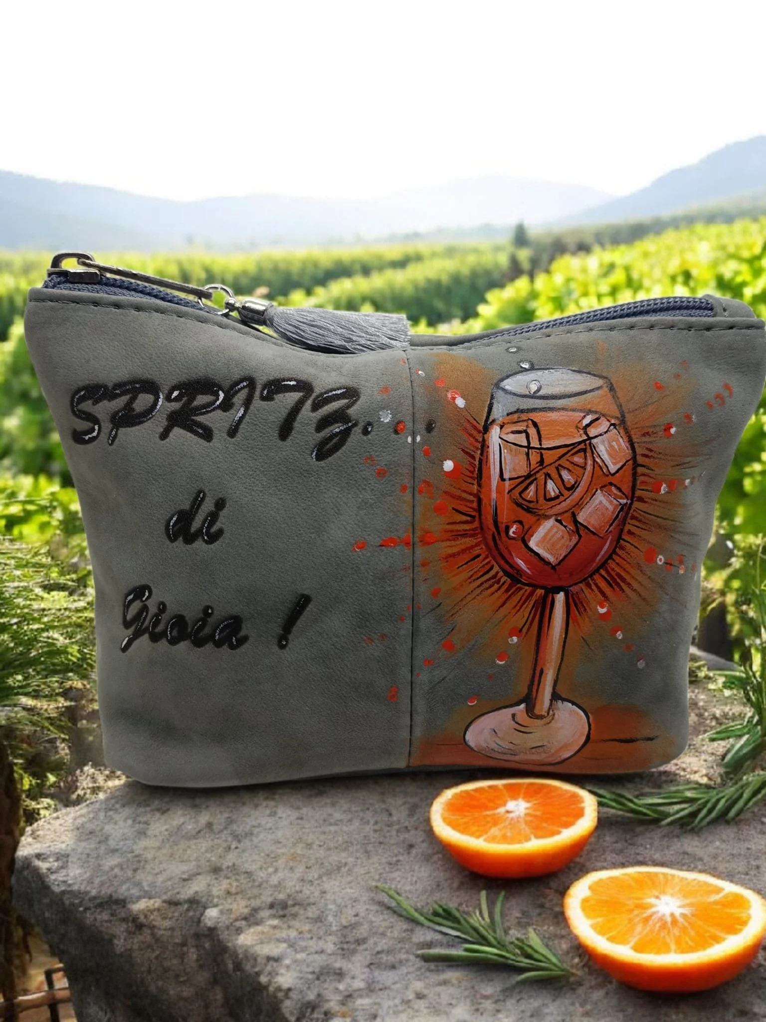 Borsa grigia decorata con una figura di un bicchiere di cocktail con ghiaccio e fetta di limone, e testo scritto a mano con aggiunta di un disegno di un bicchiere con ghiaccio e limone.