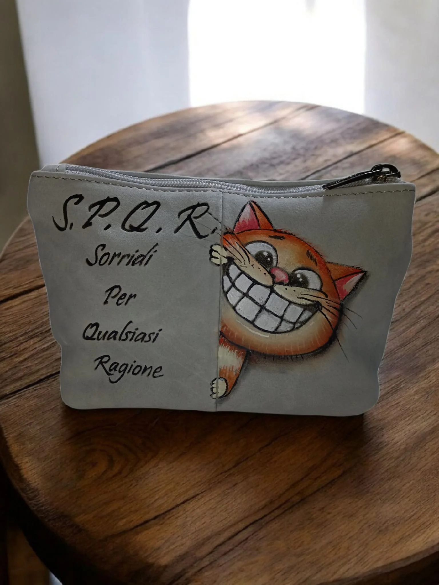 Sacchetto di tessuto con disegno di un gatto sorridente e scritte in italiano.