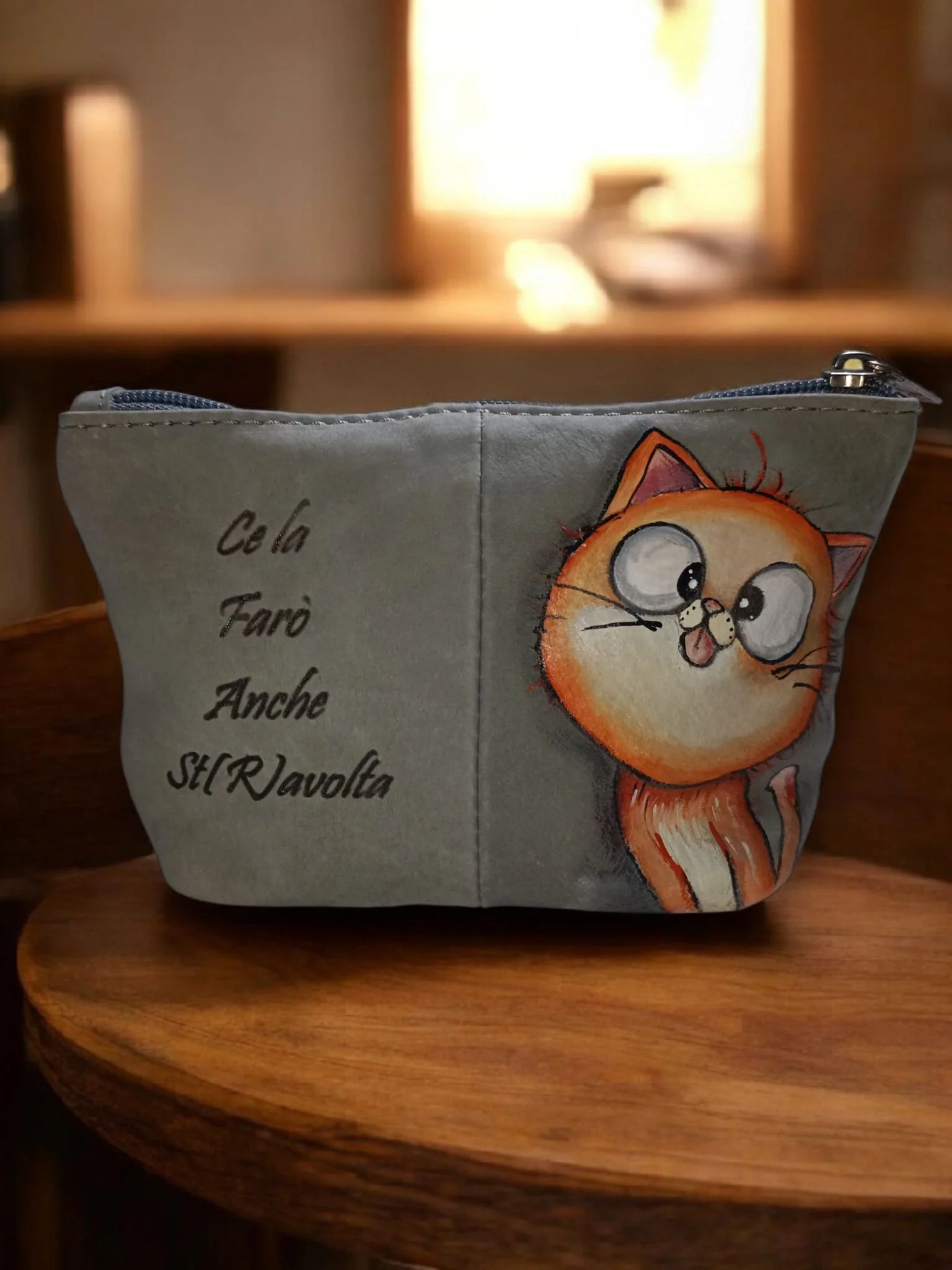Borsa grigia con grafica di un gatto con gli occhi grandi e la lingua di fuori, e scritte in italiano.