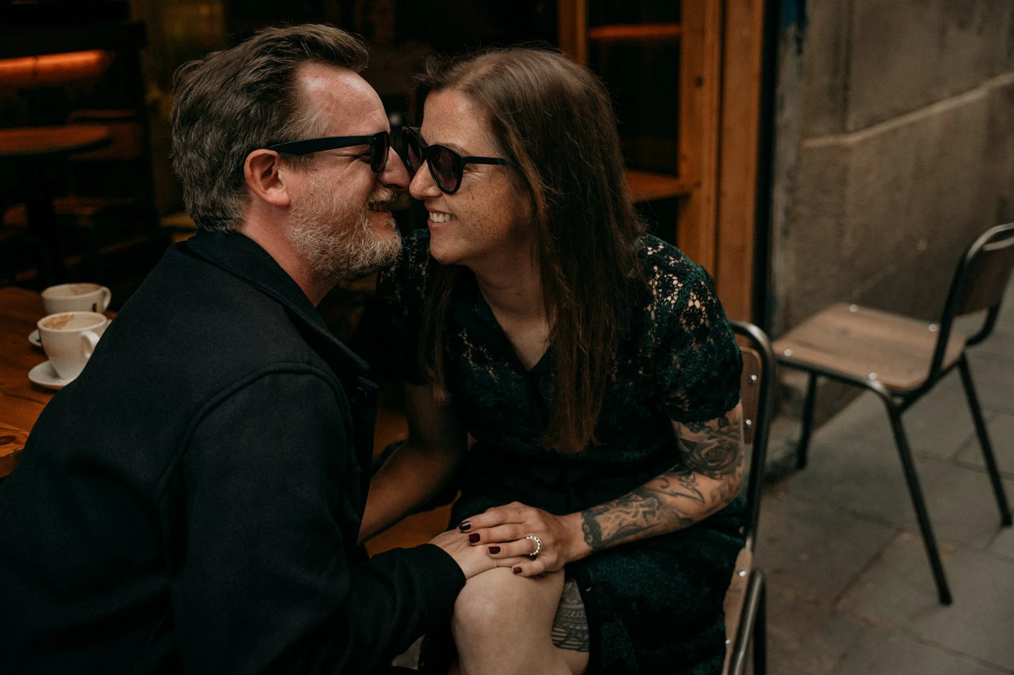 Couple touching foreheads in a cosy Barcelona café — intimate portrait session by Whip & Honey
