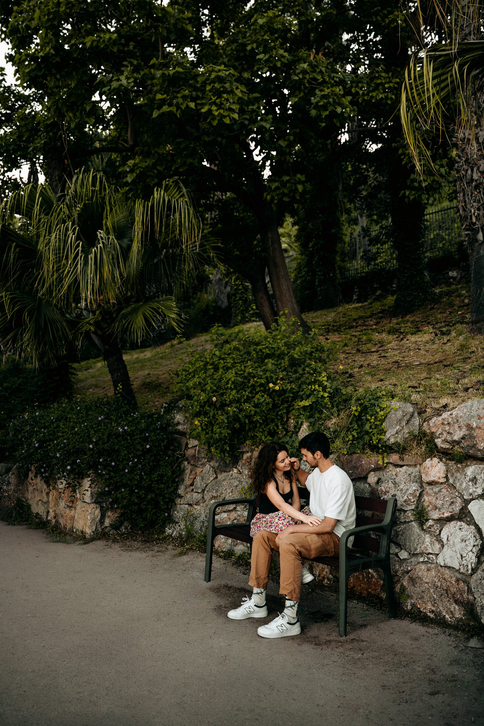 Couple sitting on a park bench holding hands in Barcelona — portrait session by Whip & Honey
