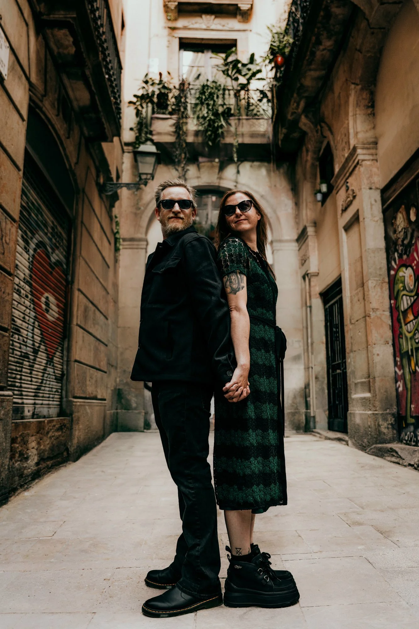 Couple holding hands in a Barcelona stone alleyway — portrait session by Whip & Honey
