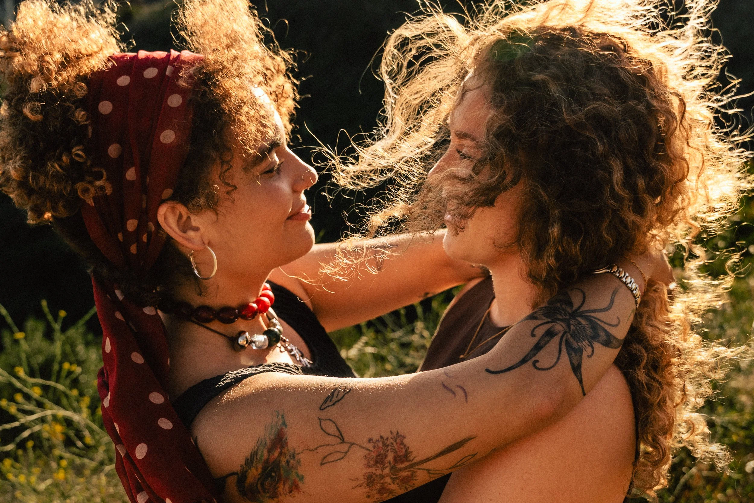 Two women hugging at sunset with Barcelona hills in the background — couples portrait session by Whip & Honey
