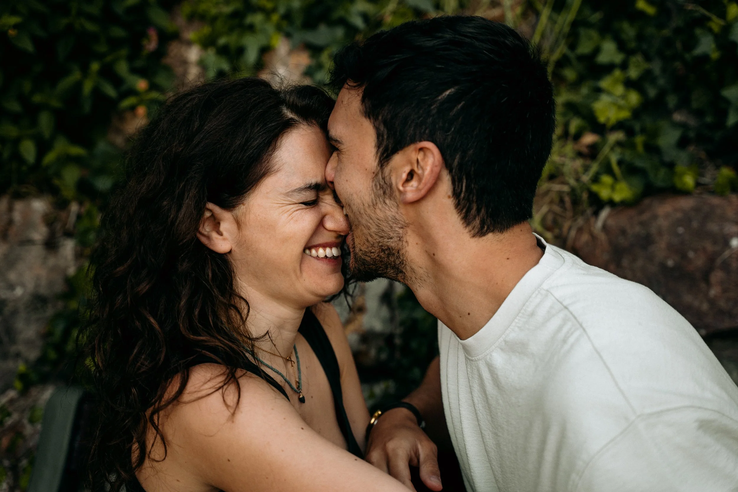 Couple with foreheads touching smiling in a Barcelona garden — portrait session by Whip & Honey
