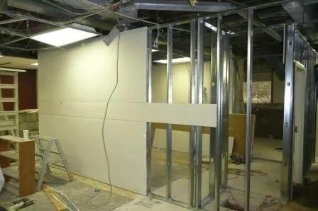 Building construction with metal framing and drywall installation in progress.