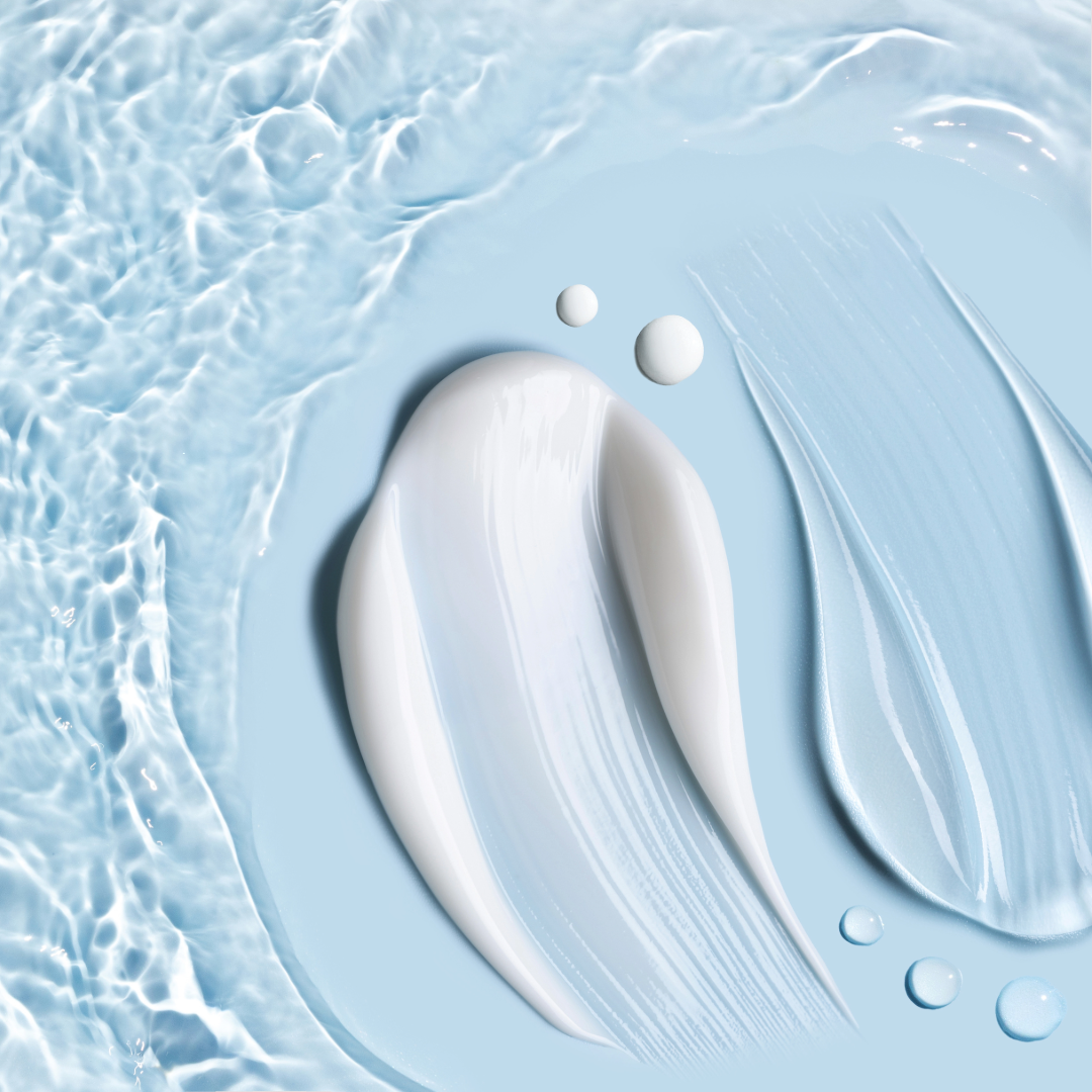 Close-up of skincare cream swatched on a light blue surface with a textured water-like background.