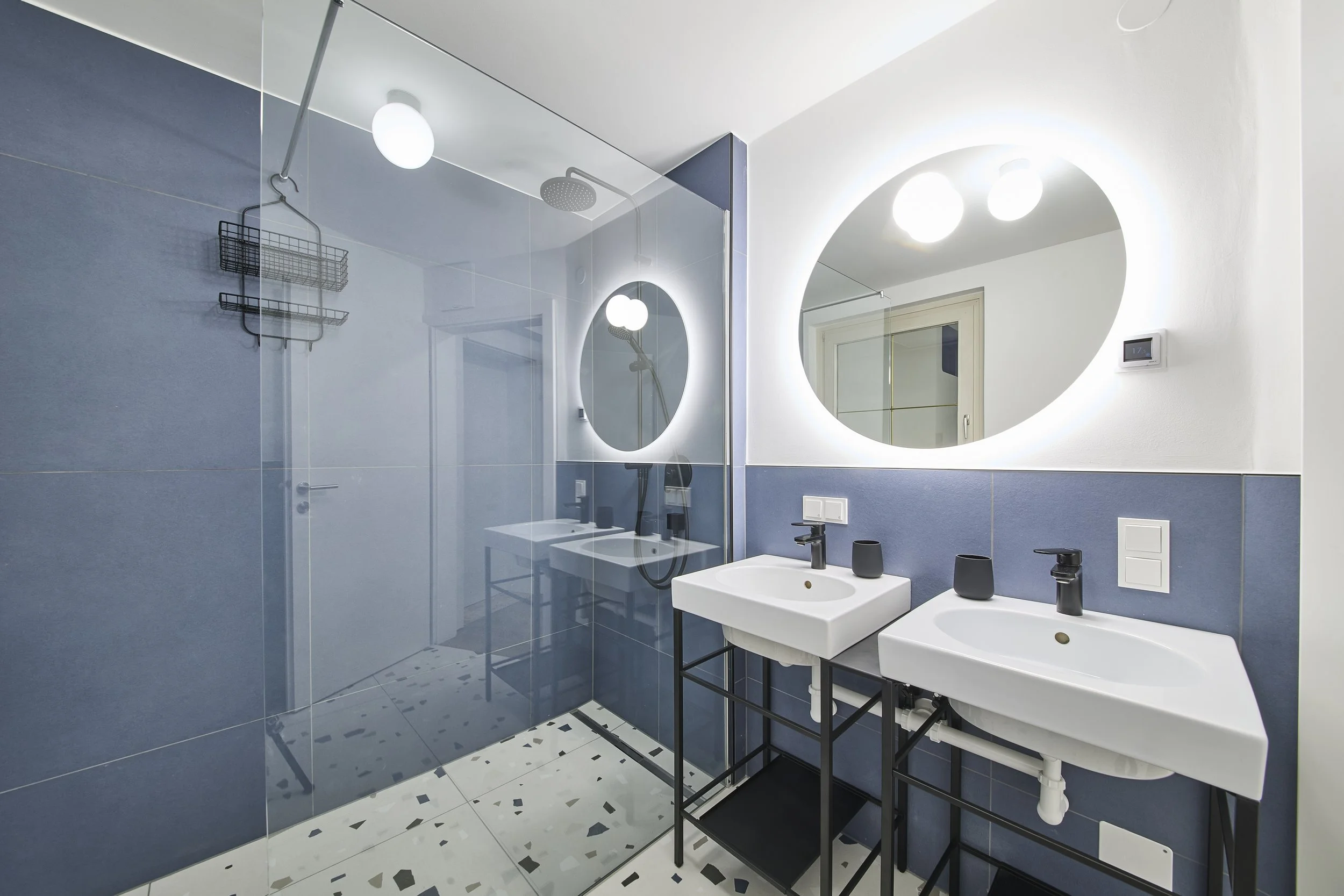 Modernes Badezimmer-Design, offene begehbare Dusche mit Glaswand, Terrazzo, runder Spiegel, blaugraue Wand