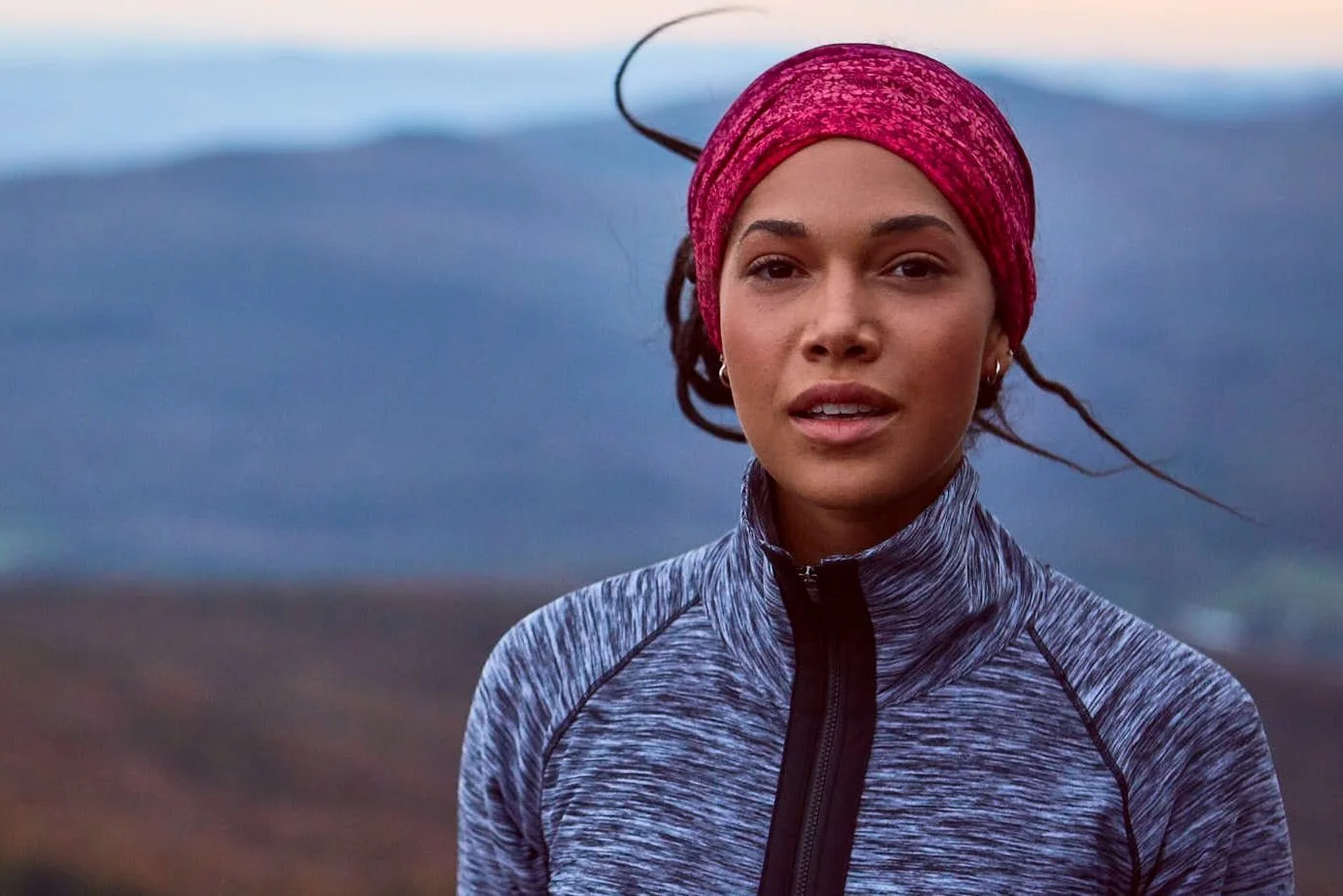 Woman in athletic wear with pink headband outdoors