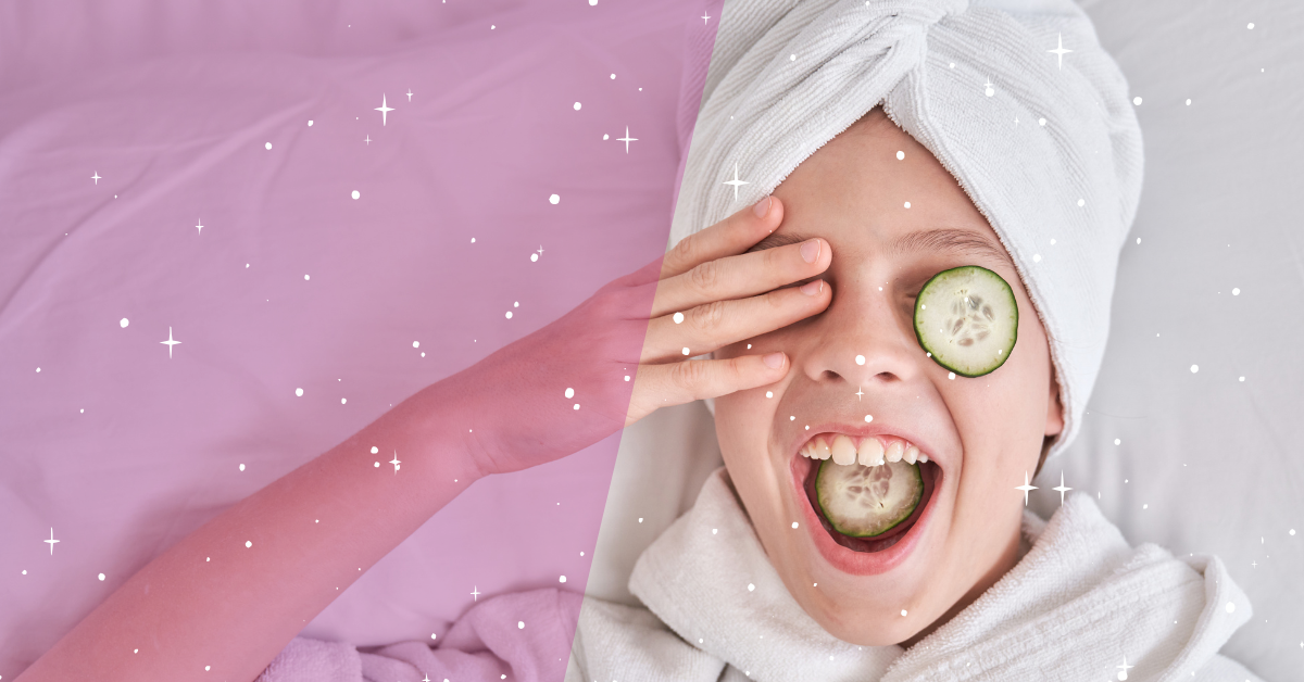 A girl with a towel on her head and cucumber slices on her eyes and mouth, smiling and laughing while lying in bed.