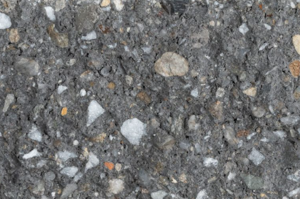 Close-up of rough gravel and dirt surface with small rocks and pebbles.
