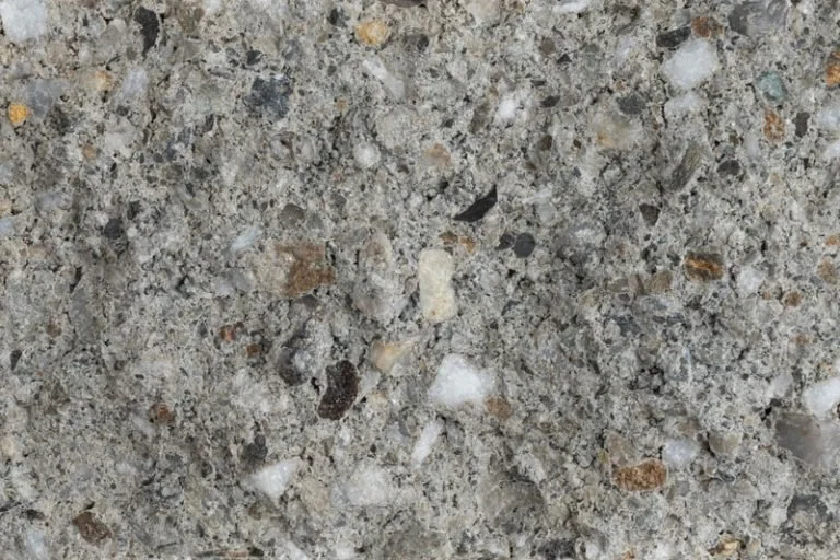 Close-up of coarse gray granite countertop surface with small white and brown mineral specks.