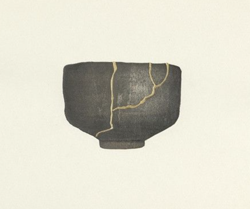 A gray ceramic bowl with visible cracks and gold inlay repairs.