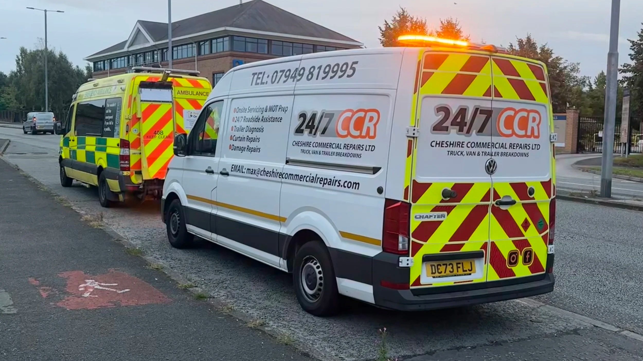Two emergency repair vans parked on the street near a building, with one van in the foreground and another slightly behind. The vans have bright yellow and red reflective safety markings, and they belong to Cheshire Commercial Repairs Ltd, offering 24/7 roadside assistance, trailer diagnosis, curtain repairs, and damage repairs.