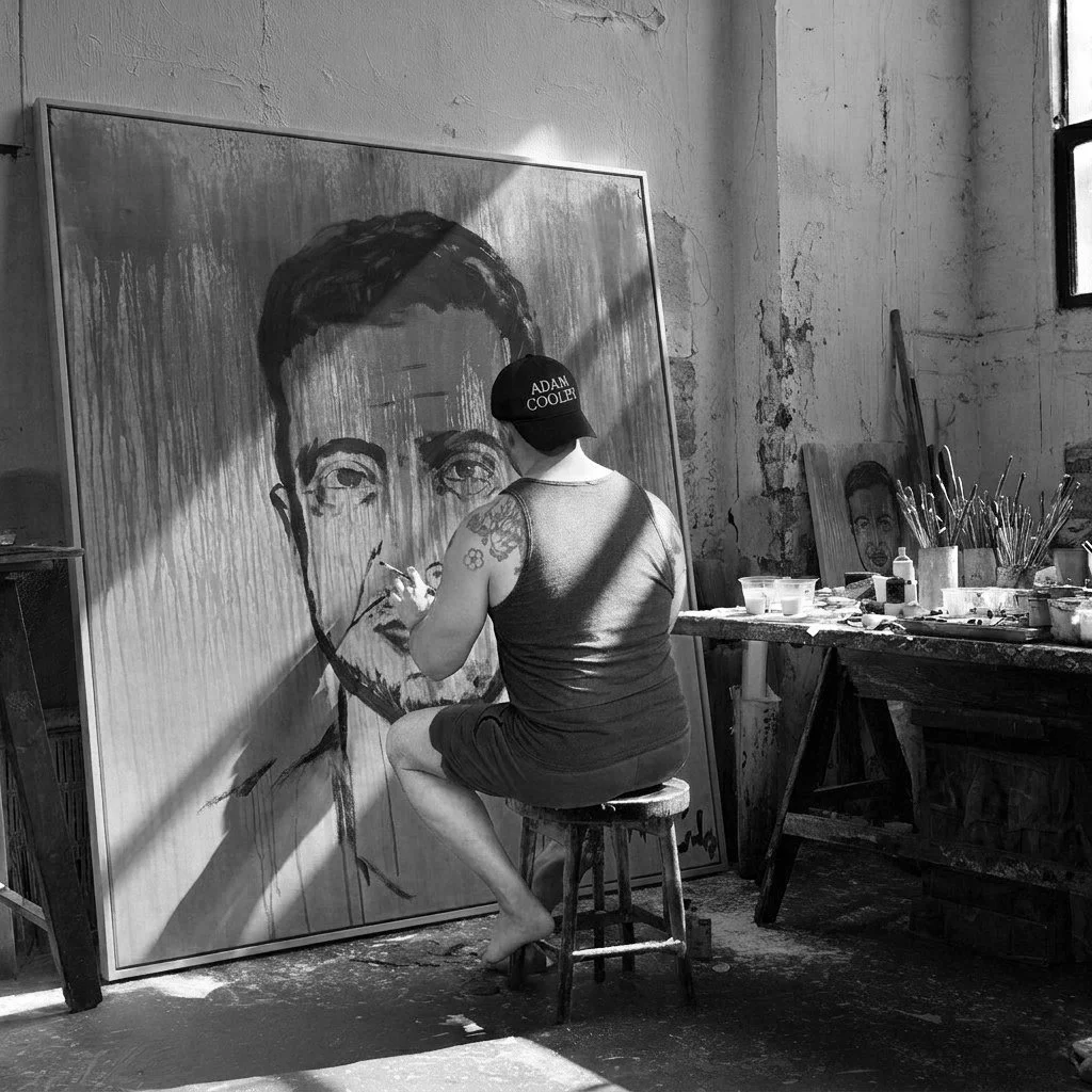 Adam Cooley painting a large portrait of Volodymyr Zelenskyy on canvas in his studio.