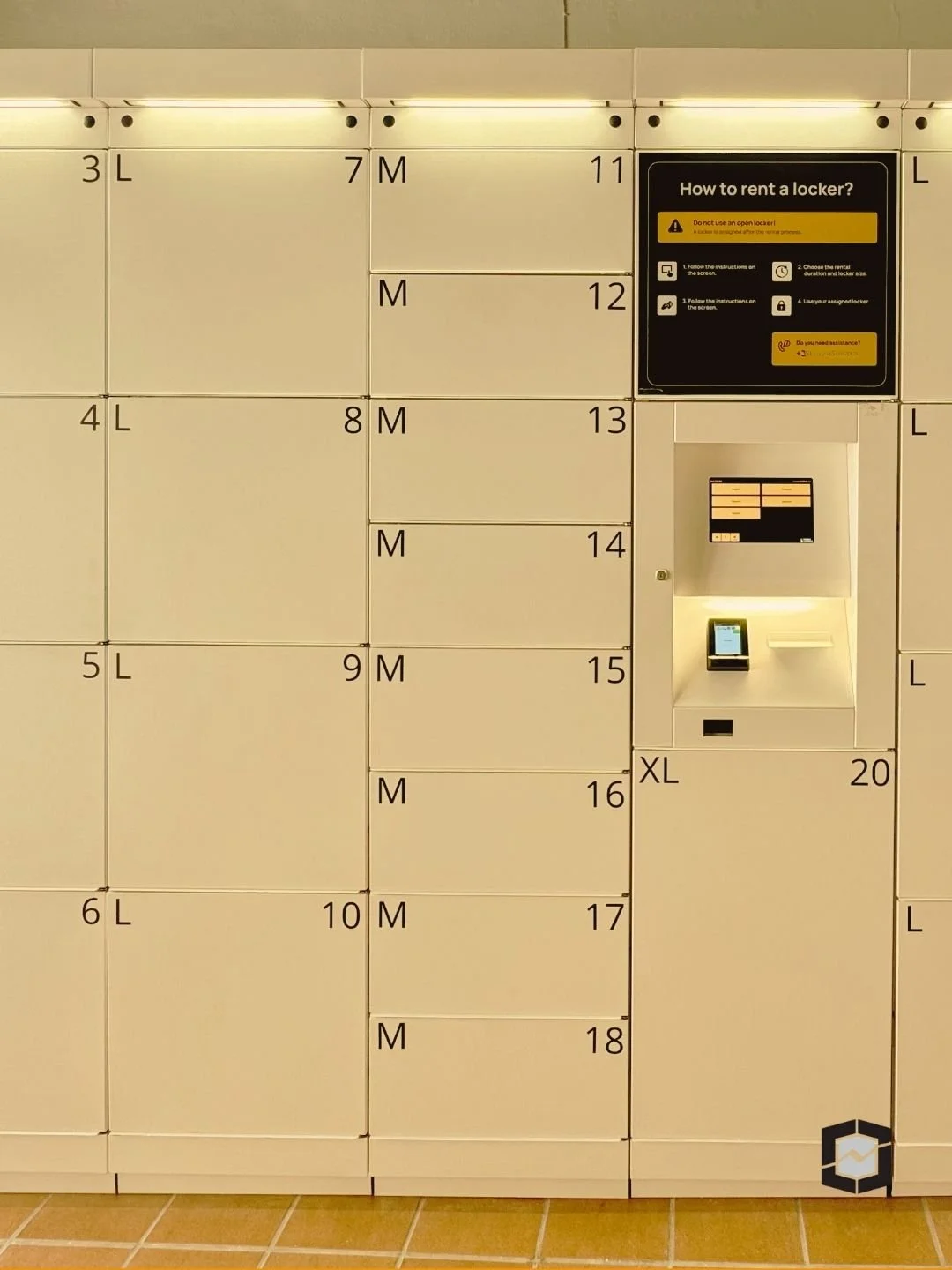 Locker system with numbered compartments, some labeled with size indicators (L, M, XL), and an instruction panel on how to rent a locker in Sliema, Malta