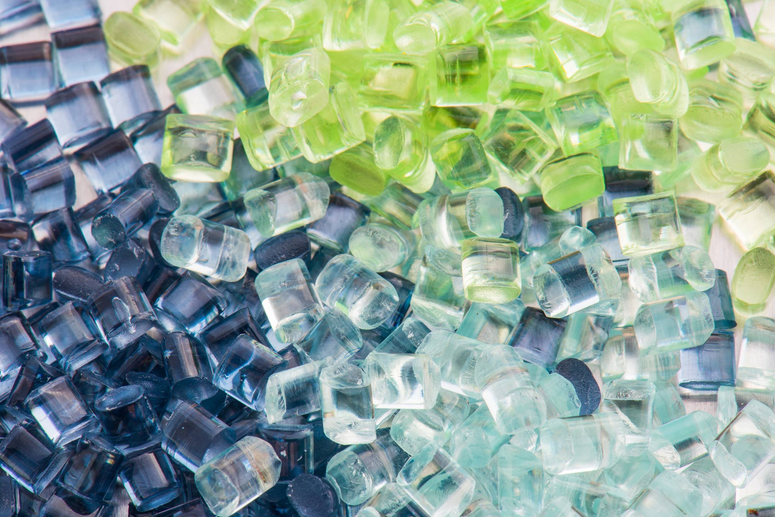 Close-up photo of colorful glass mosaic tiles in shades of blue, green, and light blue.