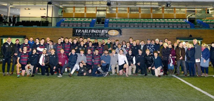 A group photo of OGRFC players and supporters infront of the stands at Ealing Trailfinders RFC