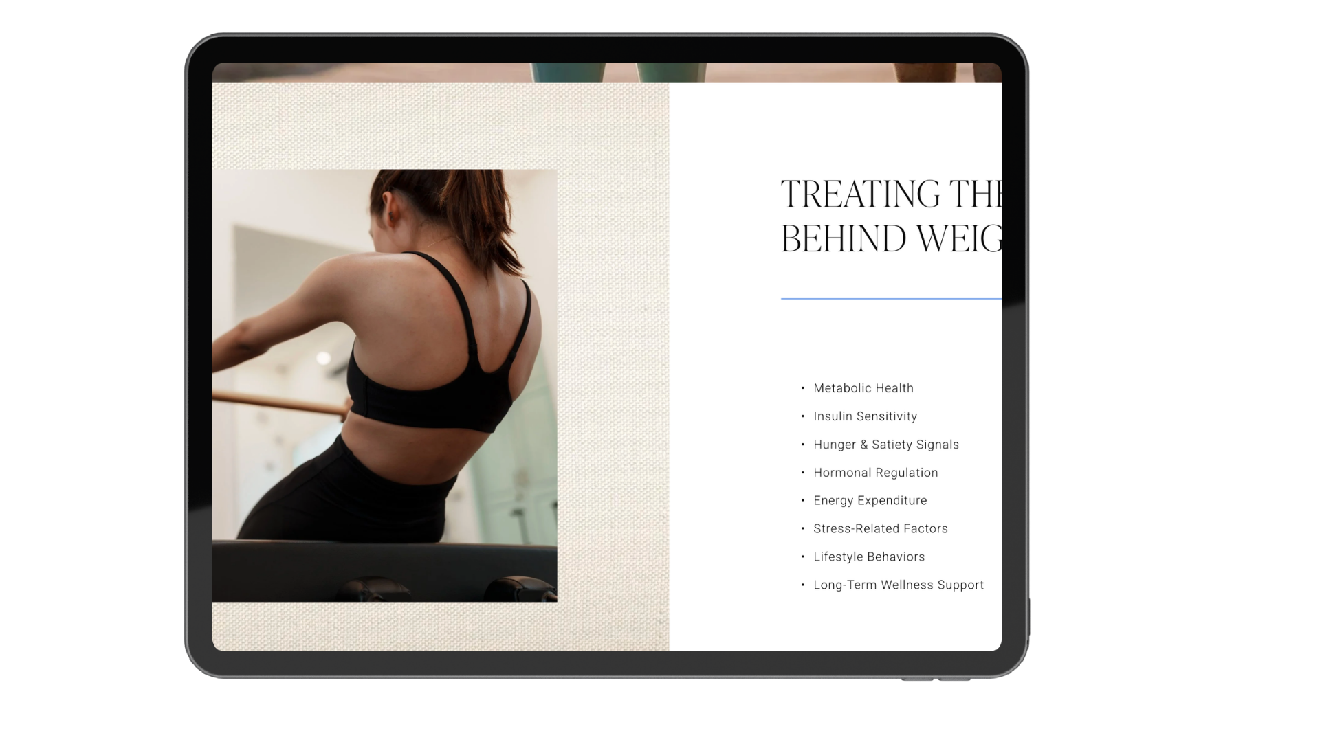 A person in a black sports top stretching at ballet barre in a dance studio, with a presentation slide on health topics visible on a computer screen