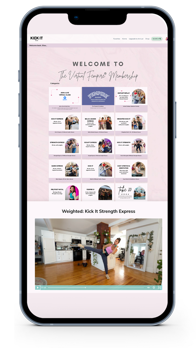 Screenshot of a mobile device displaying a fitness membership website titled 'Kick It for The Virtual Empire Membership' with various workout categories and a video of a woman doing a kick exercise in a home kitchen.