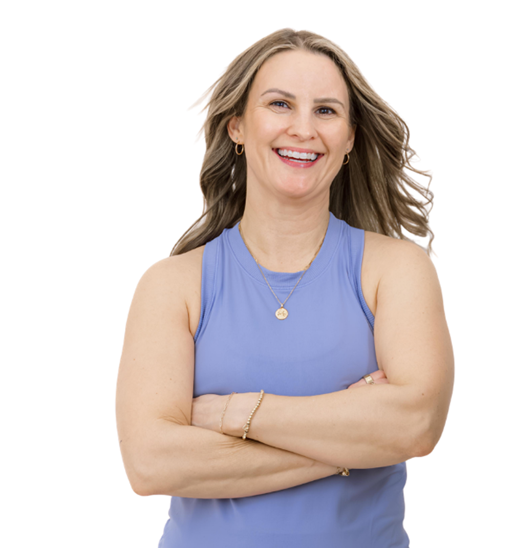 A smiling woman in a blue sleeveless top with arms crossed, blonde hair, wearing gold jewelry, against a white background.