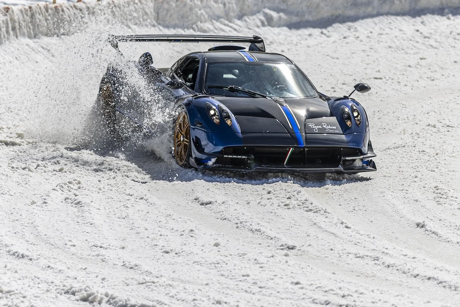 A racing car driving through snow, kicking up snow spray behind it. F.A.T. ICE RACE 2026, Big Sky, Montana USA. Dan Lakatos Photo