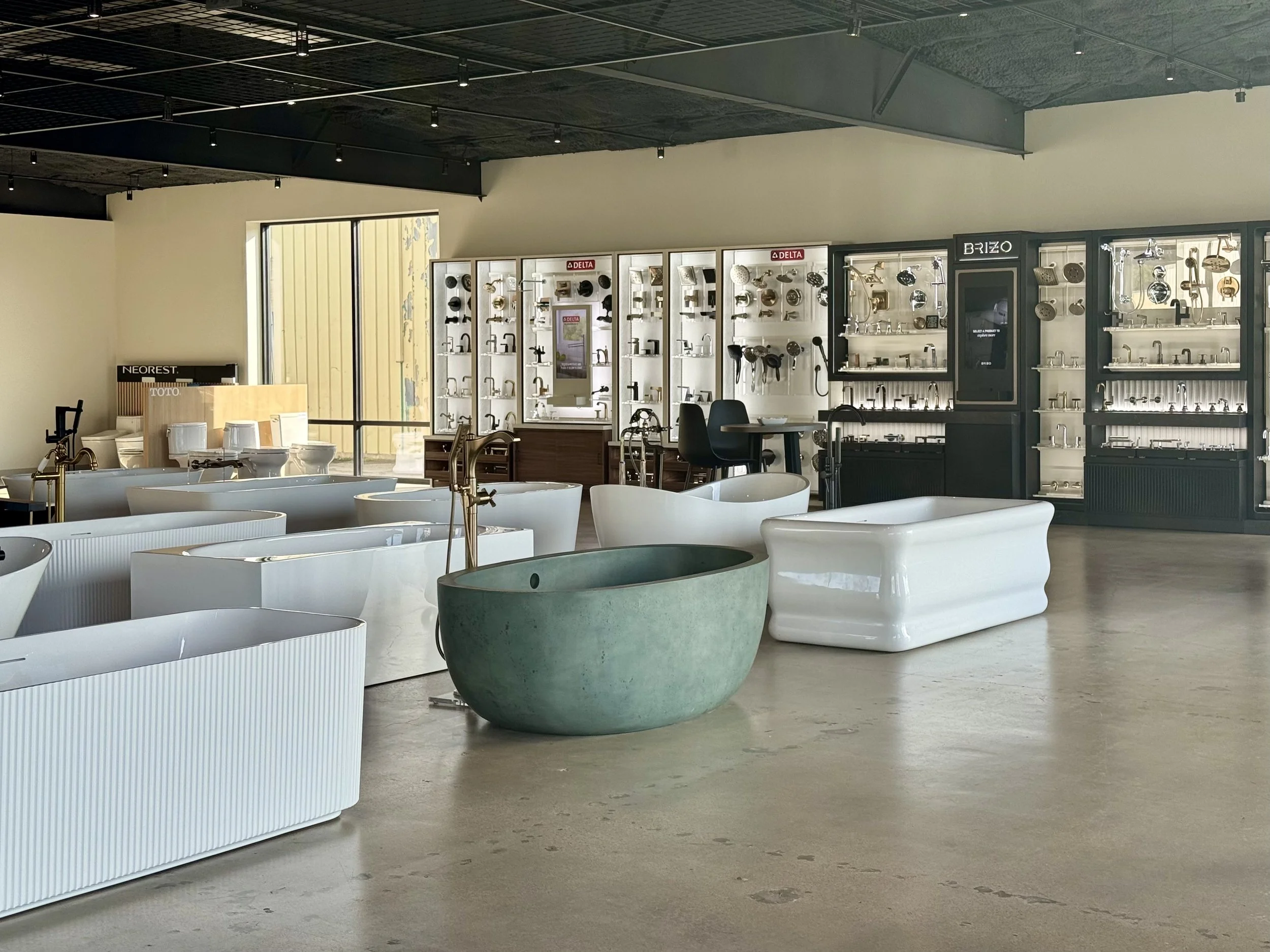 Interior of a bathroom fixtures showroom displaying various sinks, faucets, and bathroom fixtures with a modern design.